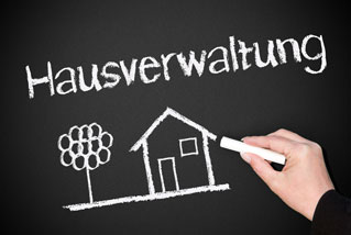 Tafel mit Aufschrift Hausverwaltung und Bild mit Haus und Baum